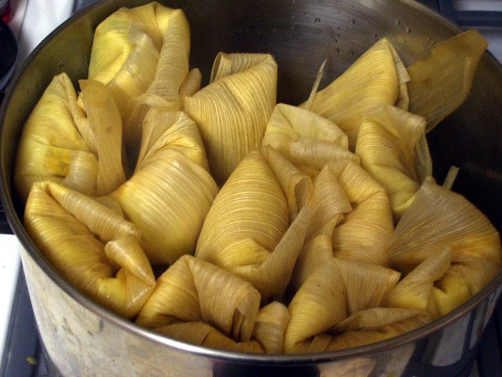 A pot of fresh homemade tamales, wrapped in corn husks