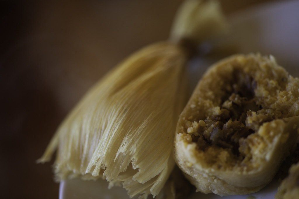 Green salsa chicken tamale, opened to show the filling